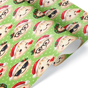 May include: A roll of wrapping paper with a light green background featuring a white polka dot pattern. The paper is decorated with a repeating print of cartoon dumplings wearing red Santa hats, some with glasses, sunglasses, or heart eyes.