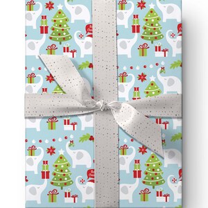 May include: A wrapped gift with light blue wrapping paper featuring a repeating pattern of white elephants, green Christmas trees, and red gift boxes. A silver ribbon with a bow secures the package.