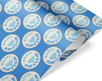 May include: Blue wrapping paper with a repeating pattern of circular designs. Each circle features a menorah illustration and the words "Happy Hanukkah" in teal and white, with a star accent. The paper is partially unrolled.