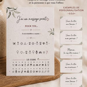 May include: A rectangular off-white card with a speckled texture featuring a secret message in French, a symbol-based cipher key, and five smaller rectangular cards showing examples of personalized messages with botanical accents.