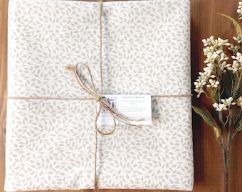 Coated tablecloth. White and beige foliage