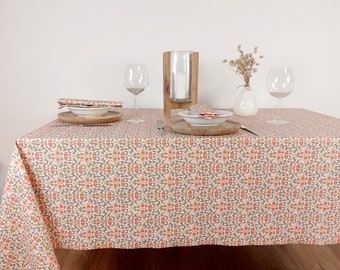 Nappe enduite française  en coton des Vosges. Motif vintage floral orange et beige. Nappe ronde, carré, rectangle, ovale et sur-mesure.