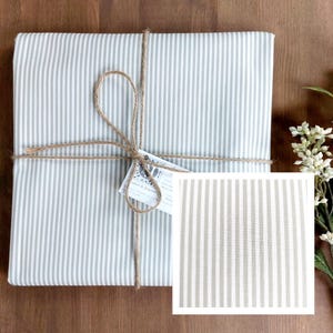Coated cotton tablecloth from the Vosges region with white and beige stripes.