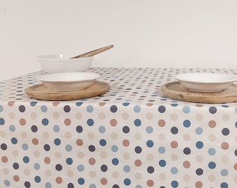 Coated tablecloth with blue and beige polka dots on a cream background