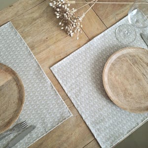 Sets de table en coton enduit à motifs géométriques beige. Fabrication française