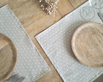 Beige geometric patterned coated cotton placemats. Made in France