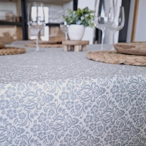 Nappe enduite, lavable à l'éponge. Motif floral baroque bleu ciel.