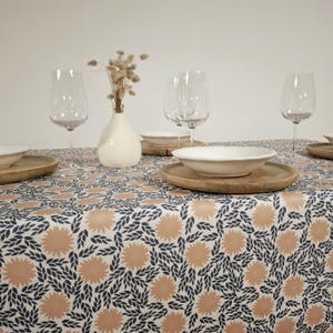 Nappe en tissu enduit facile à entretenir. Feuillage bleu et fleurs rose saumon