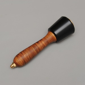 May include: A wooden mallet with a black rubber head and a brass tip. The handle is made of a dark wood with a striped pattern.