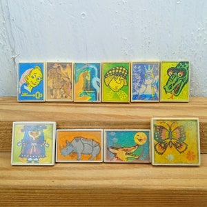 May include: A set of ten colorful vintage tile-like stickers featuring various illustrations, including a girl in a dress, a rhino, a fox, a butterfly, a camel, a bird, a snake, a girl with a crown, a boy with a key, and a girl with a crown.