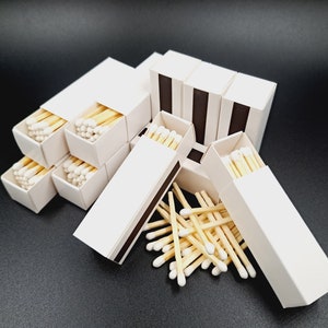 Estas cajas de cerillas blancas cuidadosamente seleccionadas para bodas o fiestas vienen en juegos de 10. Cada una cuenta con un encendedor y contiene 24 cerillas de porcelana blanca.