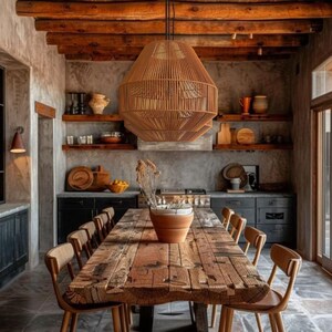 May include: A rustic dining room featuring a large, weathered wooden table with matching chairs. A woven pendant light hangs above the table. The room has exposed wooden beams and stone flooring, creating a warm, inviting atmosphere.