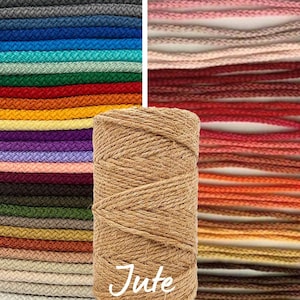 May include: A close-up of a spool of natural jute twine. The twine is a light brown color and has a rough texture. The spool is labeled "Jute".