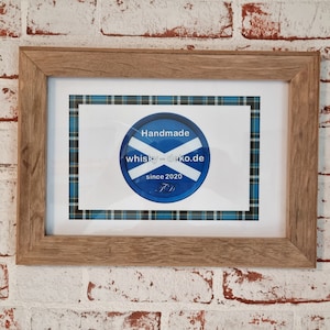 Könnte beinhalten: Ein gerahmter Druck mit einem blau-weißen schottischen Flaggen-Design. Der Druck zeigt den Text "Handmade whisky-deko.de since 2020".
