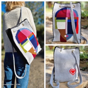 May include: A gray crochet backpack with a black trim and a colorful abstract design on the front. The design features geometric shapes in red, pink, blue, green, and brown. The bag has a drawstring closure and shoulder straps.