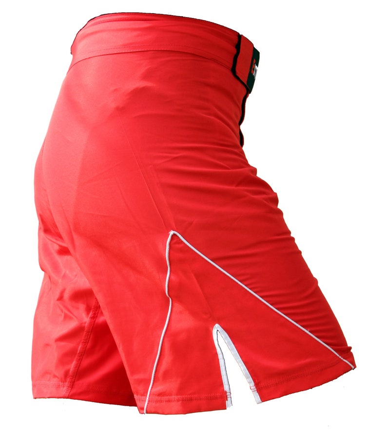 K&ouml;nnte beinhalten: Rote Sport-Shorts mit wei&szlig;em Besatz und einem seitlichen Schlitz. Die Shorts haben einen elastischen Bund mit schwarzem und gr&uuml;nem Besatz.