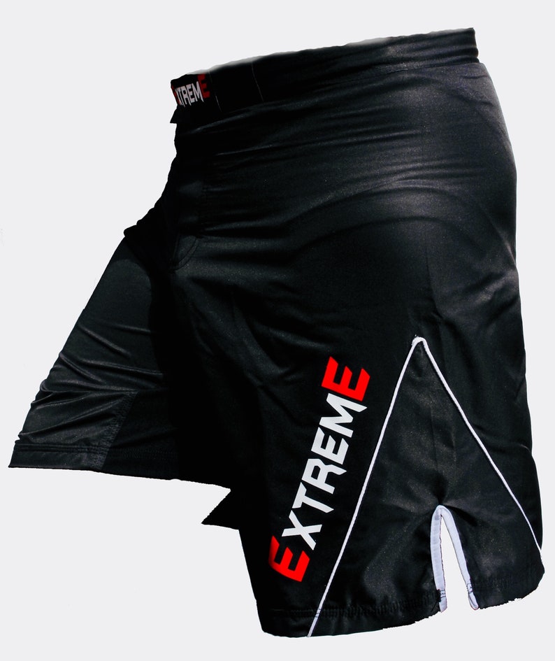K&ouml;nnte beinhalten: Schwarze Sport-Shorts mit einem wei&szlig;en und roten "EXTREME"-Logo an der Seite. Die Shorts haben einen wei&szlig;en Streifen an der Seite und einen wei&szlig;en Kordelzug.