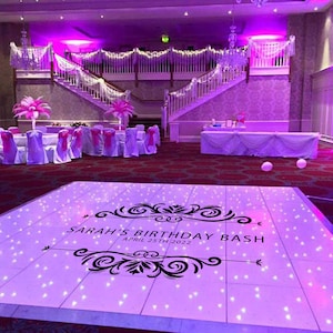 May include: A white dance floor with a black design that says "Sarah's Birthday Bash April 25th 2022". The dance floor is lit with purple lights and has small white lights embedded in the surface.