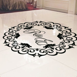 Puede incluir: Una calcomanía decorativa de suelo en blanco y negro con un diseño circular y la palabra "Bride" en una fuente estilizada.