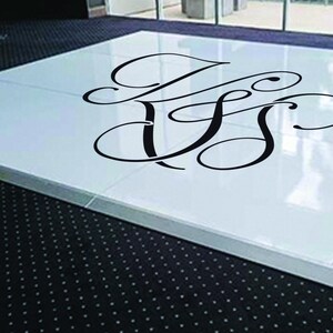 May include: A white dance floor with a black monogram of the letters "J & S" in a cursive font.