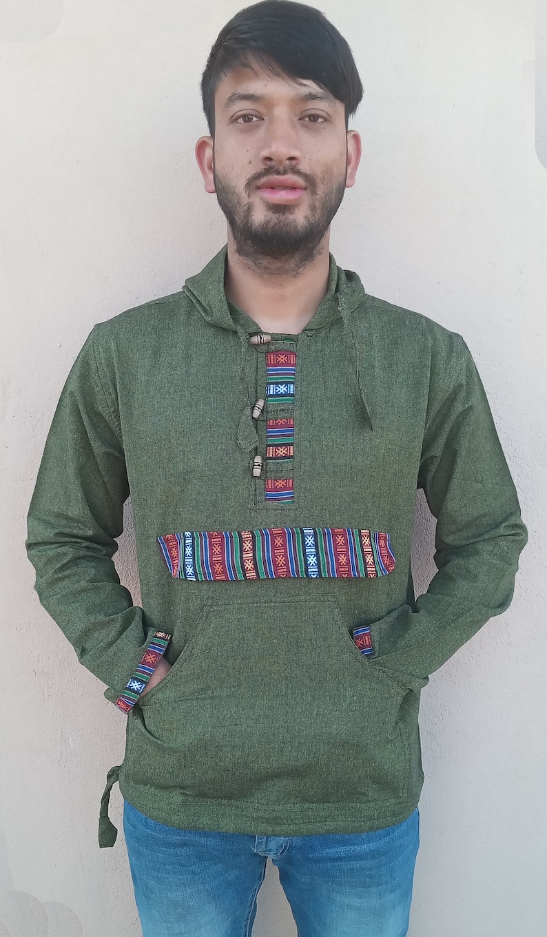 May include: A green hooded sweatshirt with a colorful patterned band across the chest and a drawstring at the bottom. The sweatshirt has a kangaroo pocket and a button closure at the neck.