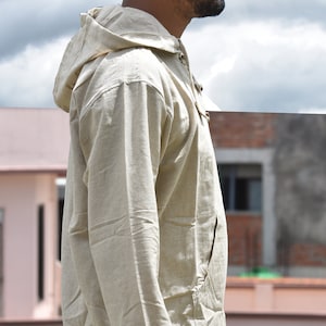 Pu&ograve; includere: Una camicia di lino beige con cappuccio, maniche lunghe e chiusura con coulisse al collo. La camicia &egrave; realizzata in un tessuto leggero e traspirante e ha una vestibilit&agrave; rilassata.