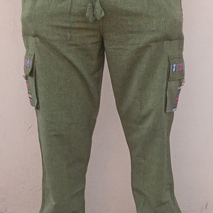 May include: Green cargo pants with colorful patterned trim on the sides and pockets. The pants have a drawstring waist and are made of a soft, comfortable fabric.