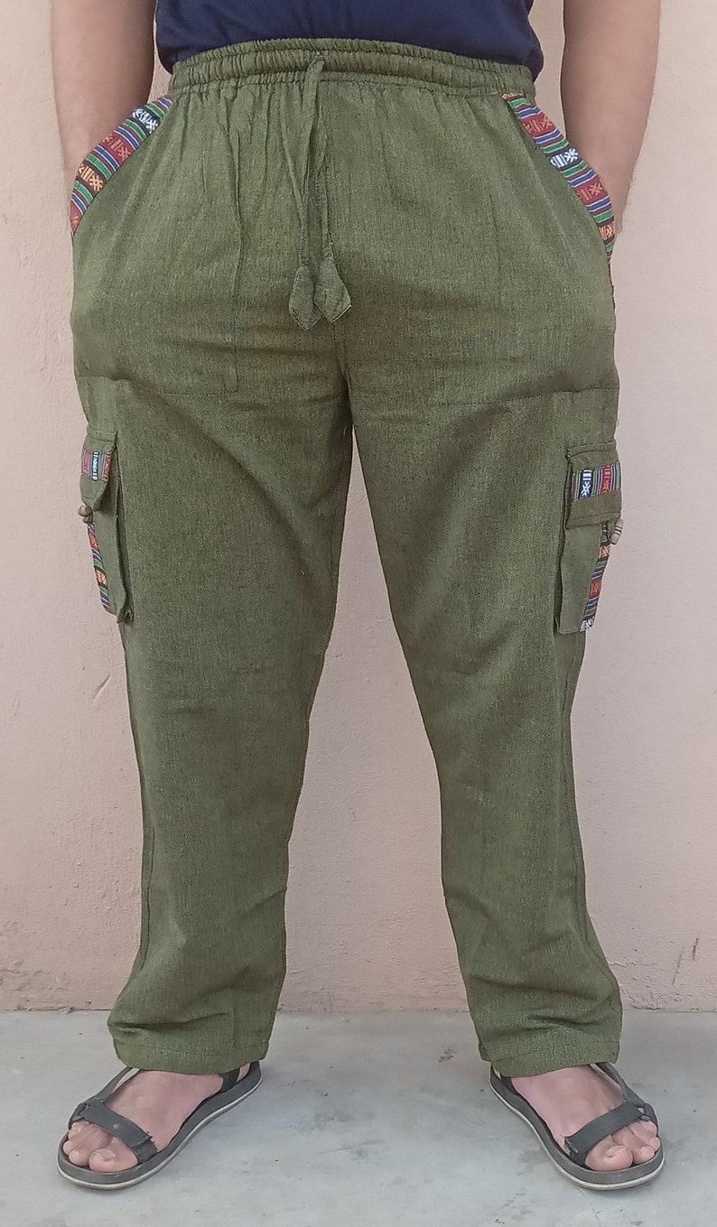 May include: Green cargo pants with colorful patterned trim on the sides and pockets. The pants have a drawstring waist and are made of a soft, comfortable fabric.