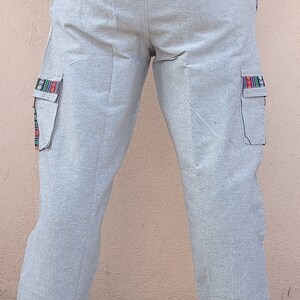 May include: Gray cargo pants with a drawstring waist and colorful trim on the pockets.