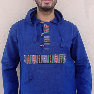 May include: A blue hooded sweatshirt with a colorful patterned trim around the neck and pockets. The sweatshirt has a kangaroo pocket and a drawstring hood.