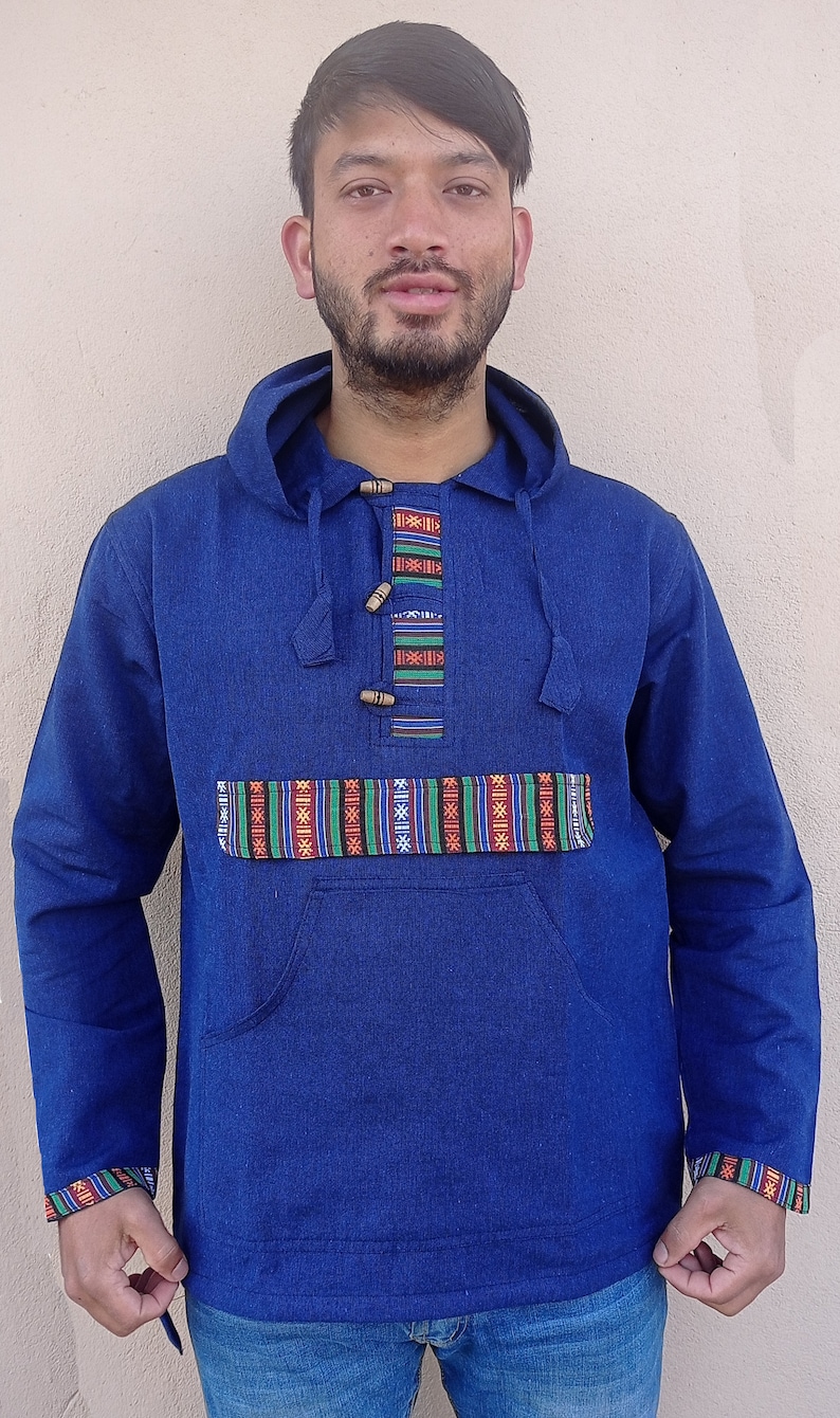 May include: A blue hooded sweatshirt with a colorful patterned trim around the neck and pockets. The sweatshirt has a kangaroo pocket and a drawstring hood.