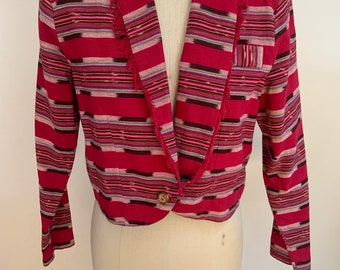 May include: A cropped, pink and black striped blazer with a fringe trim on the collar and a single button closure. The blazer has a small pocket on the left side.