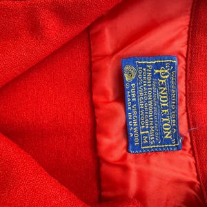 以下が含まれることがあります： 黒い持ち手と「But First, Coffee」のテキストが黒い太字で書かれた白いセラミックマグ。マグカップはぼやけた背景に置かれています。マグカップの高さは約10cmです。