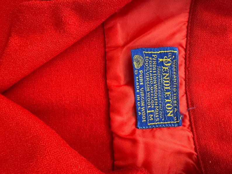 以下が含まれることがあります： 黒い持ち手と「But First, Coffee」のテキストが黒い太字で書かれた白いセラミックマグ。マグカップはぼやけた背景に置かれています。マグカップの高さは約10cmです。