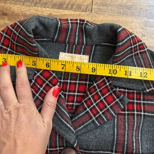 Może przedstawiać: Szara i czerwona kurtka w kratę z ż&oacute;łtą miarką na przodzie, pokazującą pomiar około 38 cm. Kurtka ma zapięcie na guziki i etykietę z napisem "Pendleton".