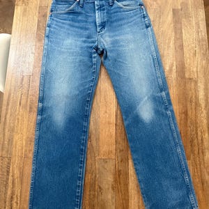 K&ouml;nnte beinhalten: Blaue Jeans aus Denim mit klassischem geradem Bein. Die Jeans haben einen Knopf- und Rei&szlig;verschluss, Front- und Ges&auml;&szlig;taschen sowie G&uuml;rtelschlaufen. Der Denim hat eine verblasste Waschung.