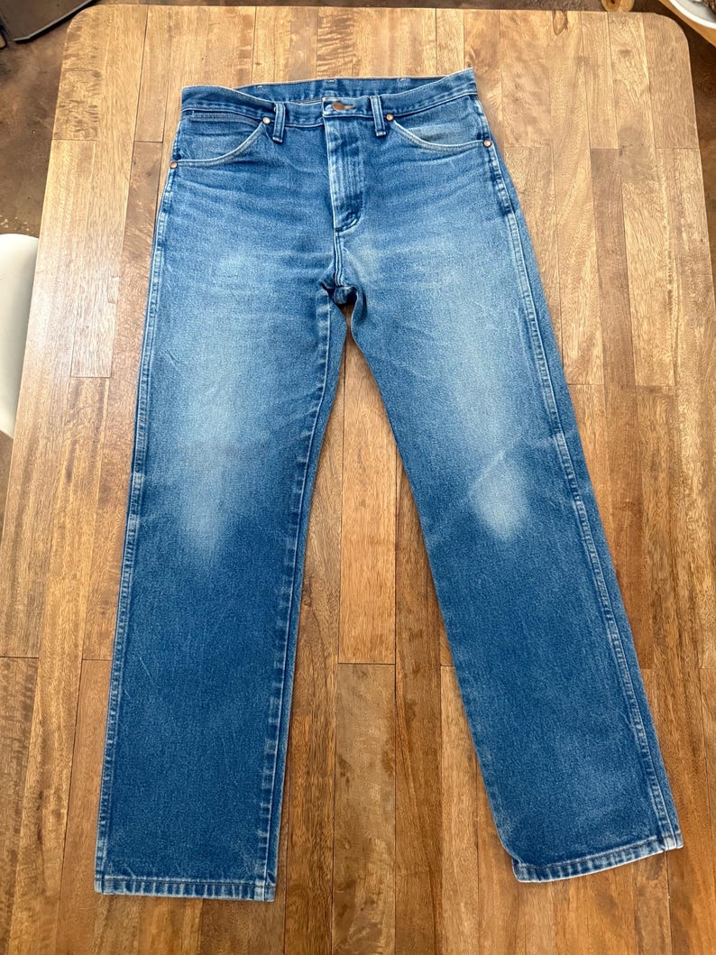 K&ouml;nnte beinhalten: Blaue Jeans aus Denim mit klassischem geradem Bein. Die Jeans haben einen Knopf- und Rei&szlig;verschluss, Front- und Ges&auml;&szlig;taschen sowie G&uuml;rtelschlaufen. Der Denim hat eine verblasste Waschung.