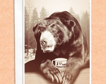 May include: A sepia-toned photo of a bear holding a coffee mug that says "I ♥ not hibernating".