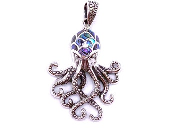 May include: A silver octopus pendant with a blue and green abalone shell inlay. The octopus has eight tentacles and is detailed with small dots.
