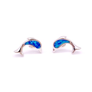 May include: A pair of silver dolphin earrings with blue opal accents.