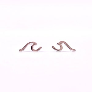 May include: A pair of silver wave earrings. The earrings are small and delicate, and they are perfect for adding a touch of whimsy to any outfit.