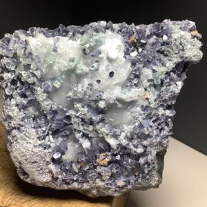 May include: A cluster of purple and green crystals with a white, milky quartz center. The crystals are arranged in a rough, natural formation.