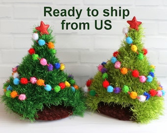 May include: Two handmade Christmas tree decorations. The trees are green with colorful pom-poms and a red star on top. The trees are in a brown pot. The text "Ready to ship from US" is above the trees.