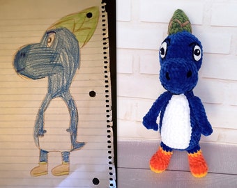 May include: A side-by-side image shows a drawing and a plush toy. The drawing is of a blue dinosaur-like creature with a green leaf-shaped headpiece. The plush toy is a blue, white, and orange crocheted dinosaur with a green headpiece.