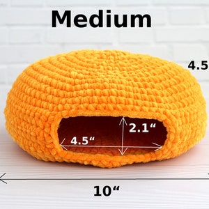 May include: A medium-sized, orange crocheted pet bed with a round shape and a hole for entry. The bed measures 10 inches in diameter, 4.5 inches in height, and the hole is 4.5 inches wide and 2.1 inches tall.