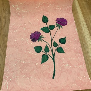 May include: A pink marbled paper with a hand-painted design of two purple roses with green leaves and stems.