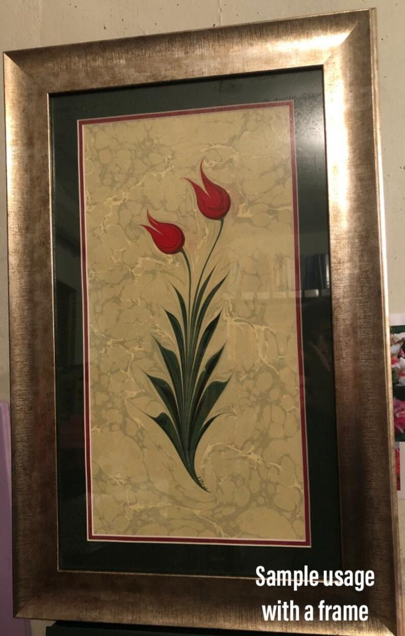 May include: A framed artwork featuring a traditional Turkish art style with two red tulips on a marbled background.