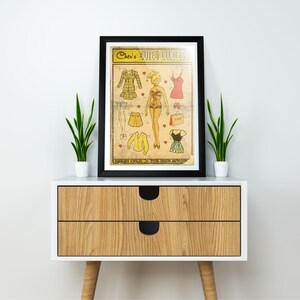 May include: A vintage-style paper doll set with a blonde doll and various outfits. The paper doll set is titled "Cher's Cute &  Clueless" and features a yellow, red, and black color scheme.