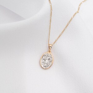 May include: A gold chain necklace with a silver oval pendant featuring a religious figure.