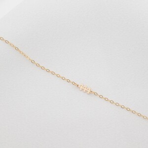 May include: A delicate gold chain necklace with a small pendant featuring the number "444".
